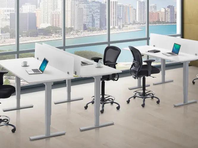 Height-adjustable benching desks with task stools by a window