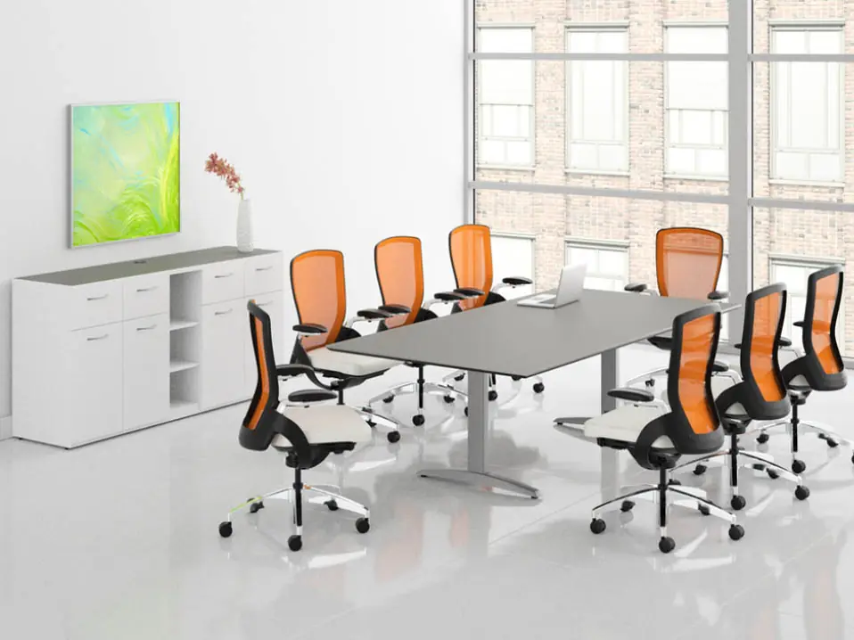Conference table with orange mesh chairs and a credenza