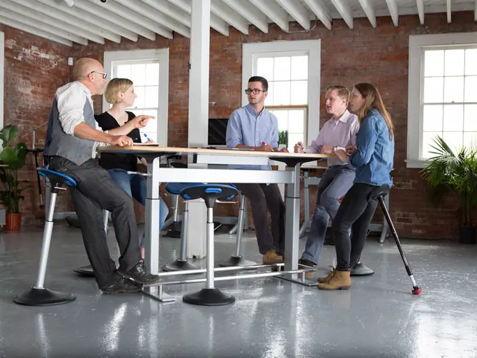 Team meeting at a standing-height table with active stools