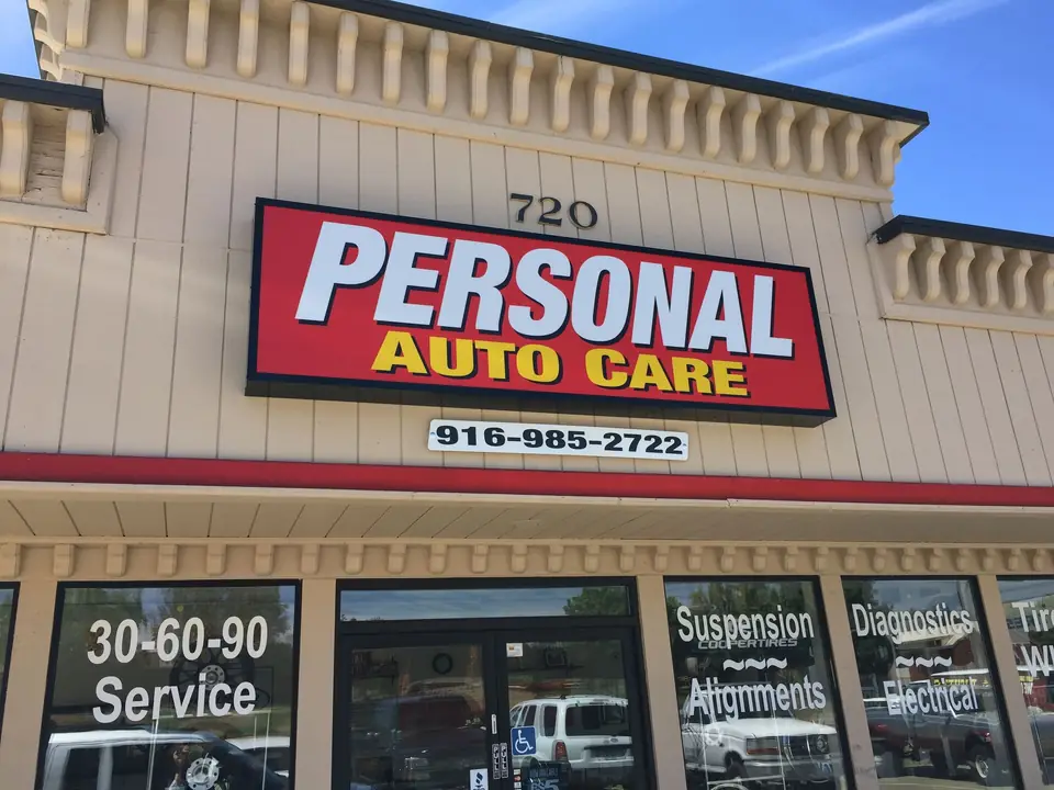 Red Personal Auto Care sign above a shopping-center storefront