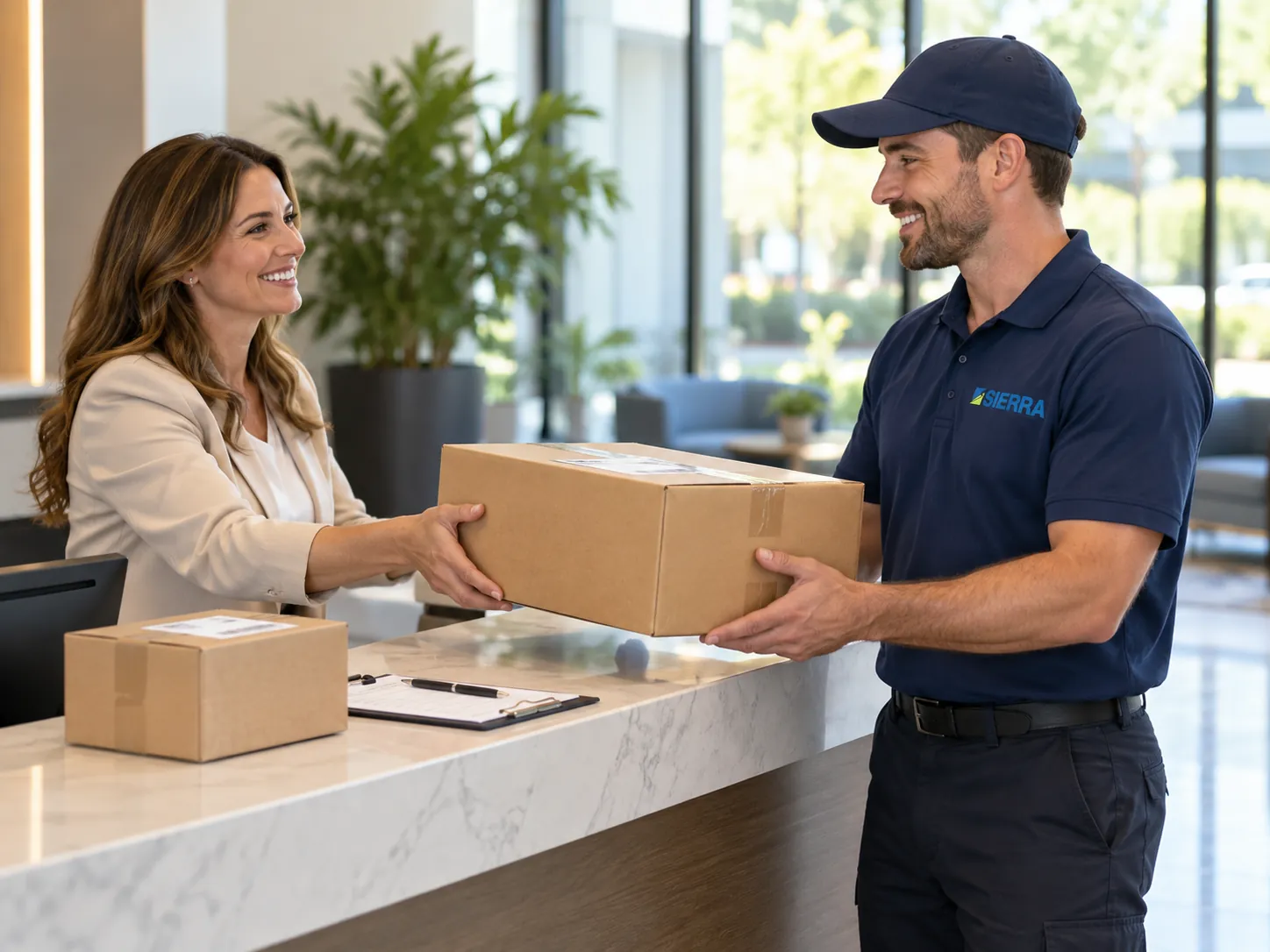 A Sierra driver picking up a sealed return carton at a client&rsquo;s reception desk